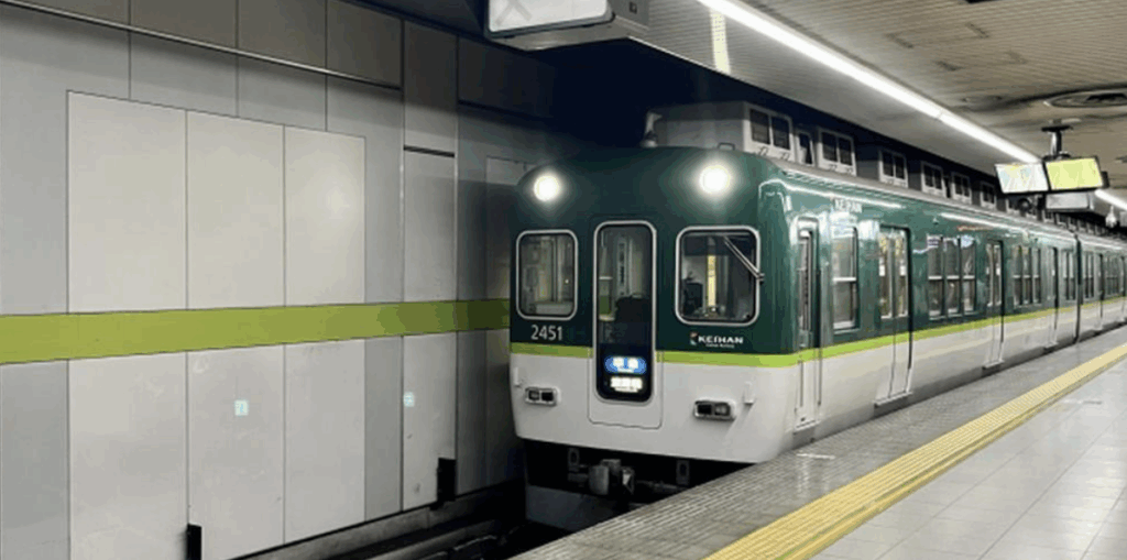 地下鉄駅のホームに停車中の緑色の電車