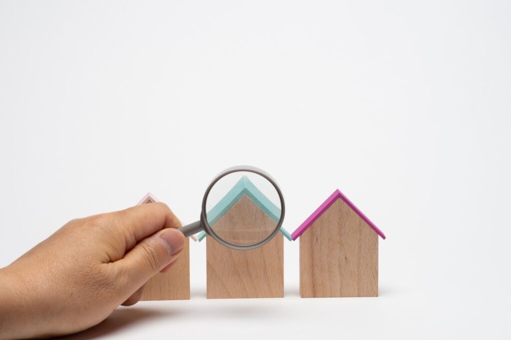 家の模型を虫眼鏡で見ている画像